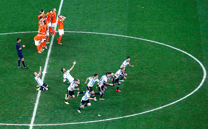 Argentina's players celebrate past the Netherlands' players after winning their 2014 World Cup semi-finals at the Corinthians arena in Sao Paulo