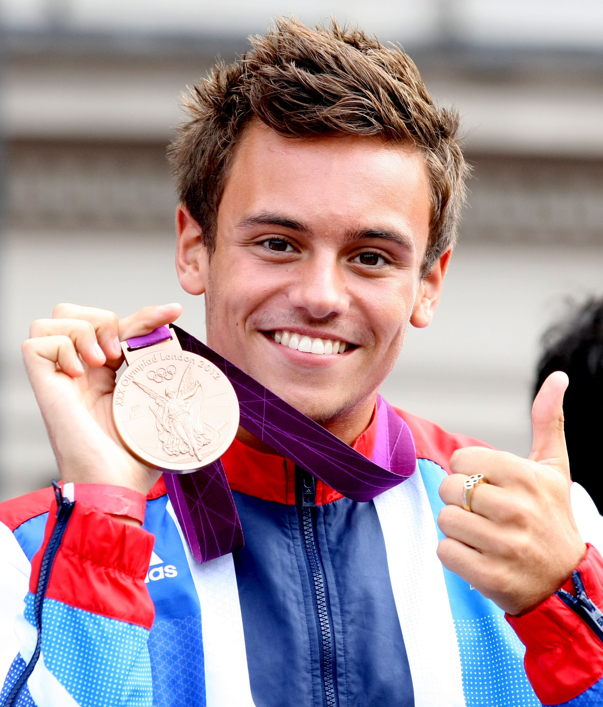 Great Britain’s Tom Daley shows his bronze medal to the crowd as the Olympi...